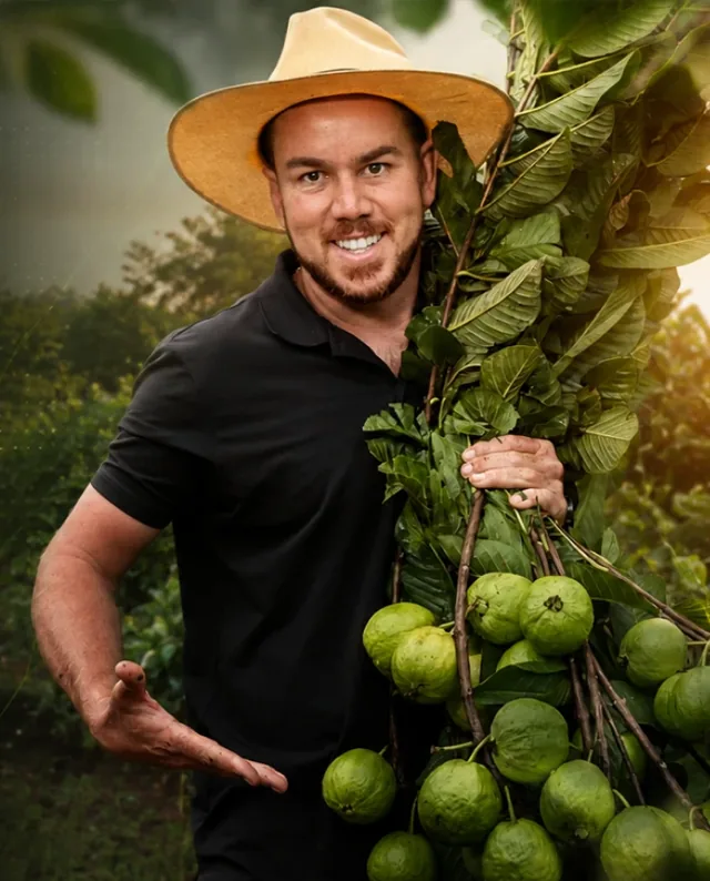 Thiago José no pomar segurando um galho com frutas
